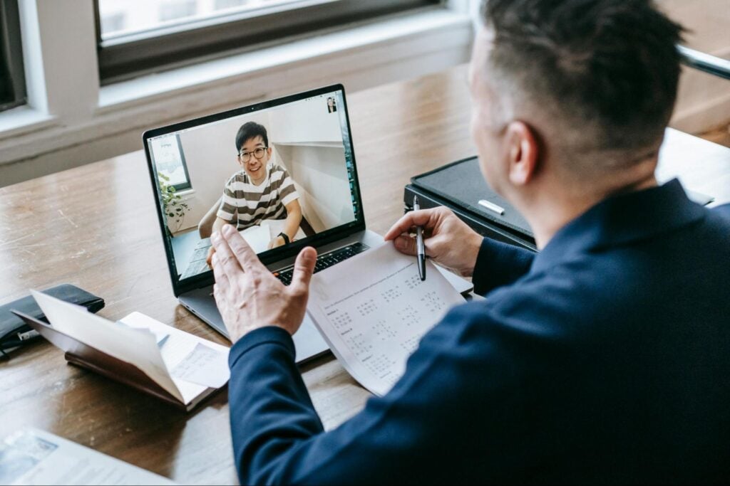 Learner attending a one-to-one online training session and taking notes.